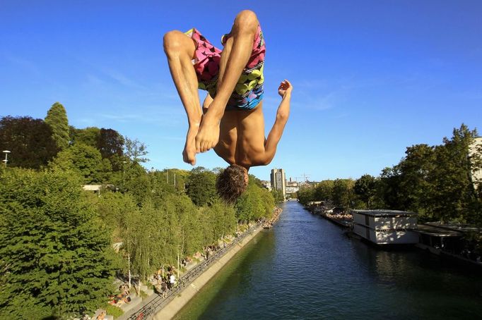 A man jumps from a bridge into the Limmat river during sunny summer weather in Zurich August 17, 2012. The Federal Office of Meteorology MeteoSwiss has launched a warning for a heat wave for the weekend until August 22. REUTERS/Arnd Wiegmann (SWITZERLAND - Tags: ENVIRONMENT SOCIETY TPX IMAGES OF THE DAY) Published: Srp. 17, 2012, 6:13 odp.