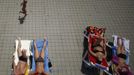 People sunbath as a child runs past them at the public swimming pool Kongressbad in Vienna June 30, 2012. Temperatures will rise up to 37 degrees Celsius (98.6 Fahrenheit) in Austria in the next days, Austria's national weather service agency ZAMG reported. REUTERS/Lisi Niesner (AUSTRIA - Tags: ENVIRONMENT TPX IMAGES OF THE DAY) Published: Čer. 30, 2012, 2:24 odp.