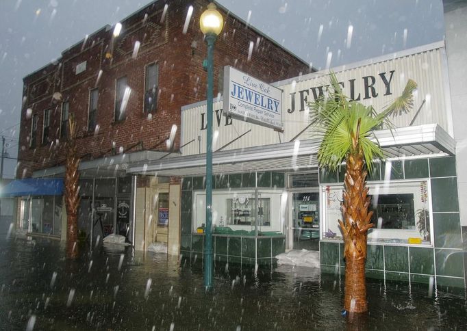 Sandbags try to hold back three to four feet of water in front of downtown businesses in Live Oak, Florida June 26, 2012. Tropical Storm Debby drifted slowly eastward over Florida's Gulf Coast on Tuesday, threatening to dump more rain on areas already beset by flooding. After stalling in the Gulf of Mexico, the storm was finally moving but was expected to take two more days to finish its wet slog across Florida. REUTERS/Phil Sears (UNITED STATES - Tags: ENVIRONMENT) Published: Čer. 26, 2012, 9:18 odp.