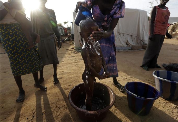 A woman washes the face of her child in a refugee camp in Sevare January 26, 2013. REUTERS/Eric Gaillard (MALI - Tags: CIVIL UNREST CONFLICT POLITICS) Published: Led. 26, 2013, 6:21 odp.