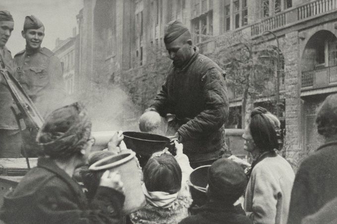 Ruští vojáci rozdávají v dobytém Berlíně polévku civilistům. Rok 1945.