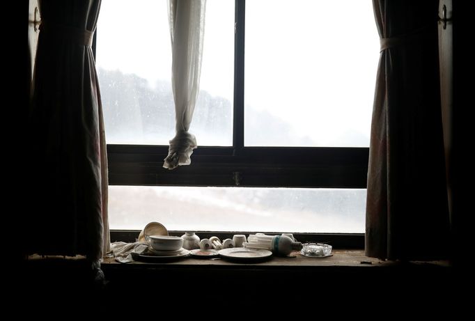 Light bulbs, bowls and plates lie on a windowsill at the abandoned Alps Ski Resort