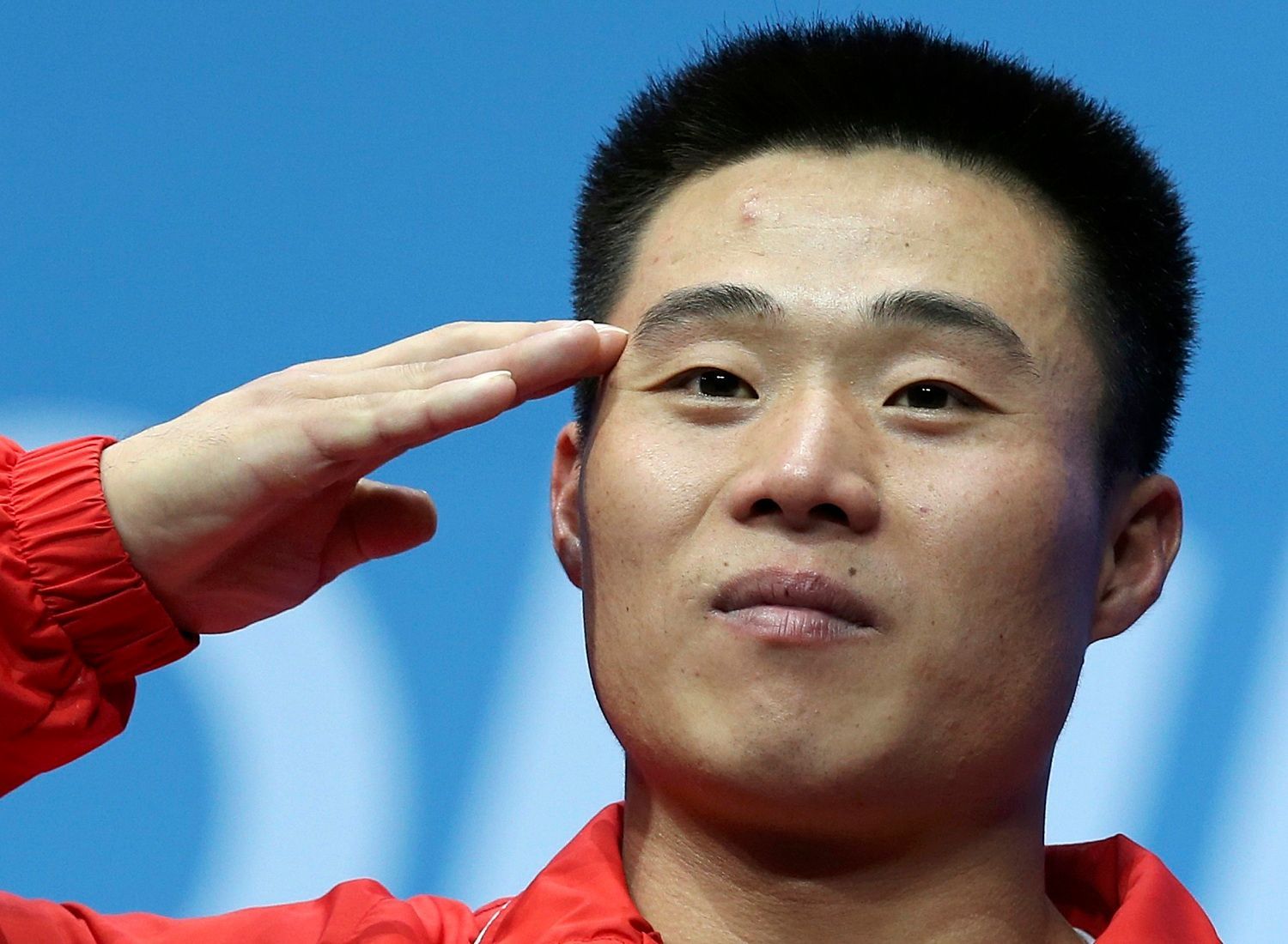 Severokorejský vzpěrač Guk Kim Un salutuje se zlatou medailí po vítězství v kategorii mužů do 62 kg na OH 2012 v Londýně.