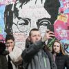 Lennonova zeď po třech měsících od malování - turisté, graffiti