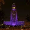 People watch as City Hall is illuminated in purple in remembrance of the late singer Prince in Downtown Los Angeles