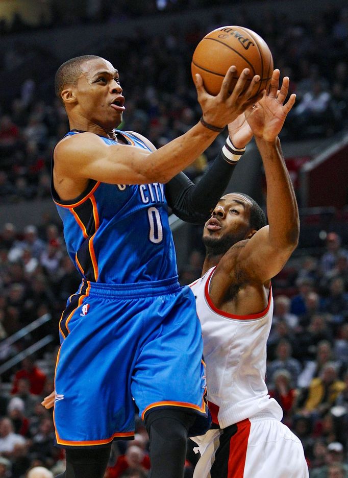 Basketbalista Russel Westbrook se snaží vystřelit přes LaMarcuse Aldridgeho v zápase Oklahomy s Portlandem