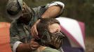 A member of the North Florida Survival Group puts a mask on his son as they gear up to perform enemy contact drills in a wooded area during a field training exercise in Old Town, Florida, December 8, 2012. The group trains children and adults alike to handle weapons and survive in the wild. The group passionately supports the right of U.S. citizens to bear arms and its website states that it aims to teach "patriots to survive in order to protect and defend our Constitution against all enemy threats". Picture taken December 8, 2013. REUTERS/Brian Blanco (UNITED STATES - Tags: SOCIETY POLITICS) ATTENTION EDITORS: PICTURE 4 OF 20 FOR PACKAGE 'TRAINING CHILD SURVIVALISTS' SEARCH 'FLORIDA SURVIVAL' FOR ALL IMAGES Published: Úno. 22, 2013, 1 odp.