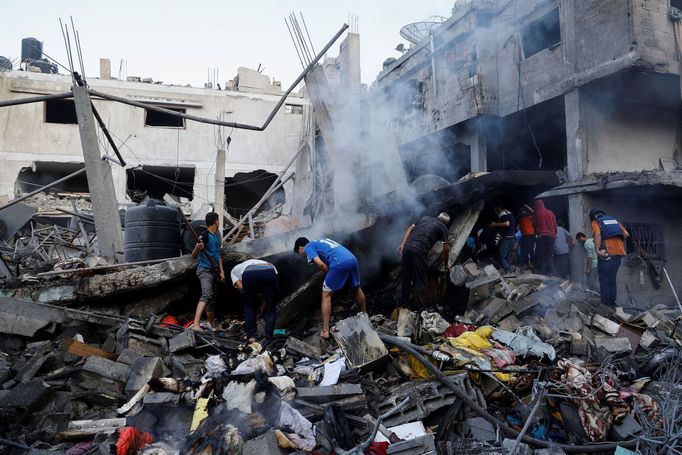 Palestinci hledají pod troskami domů zničených při odvetném útoku Izraele přeživší.