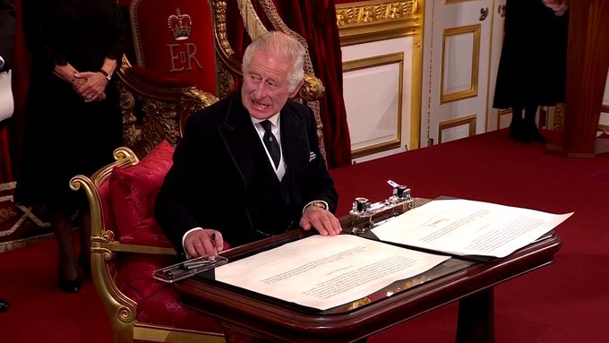 Král Karel III. vybízí pomocníka, aby mu odnesl pero