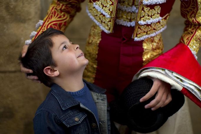 A boy looks at Spanish matador Fernandez before the start of a bullfight in Seville