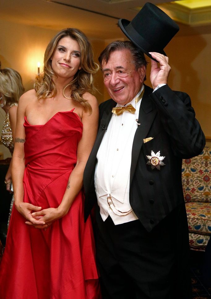 Italian actress Canalis poses in a dress by British designer Westwood with her host Austrian businessman Lugner ahead of the Opera Ball in Vienna