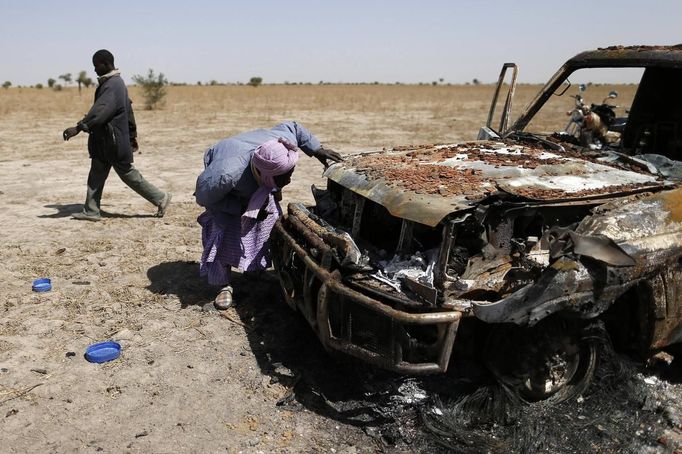 A Tuareg man looks a destroyed vehicle used by Islamist rebels on a road between Diabaly and Timbuktu January 30, 2013. REUTERS/Benoit Tessier (MALI - Tags: POLITICS CIVIL UNREST) Published: Led. 30, 2013, 11:09 odp.