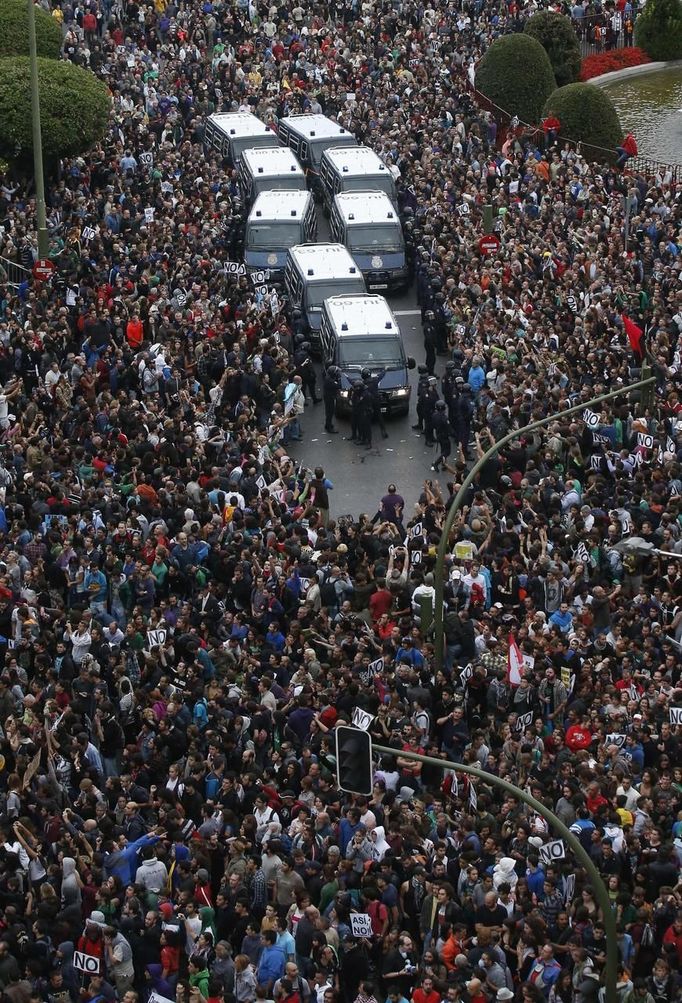 Protesters surround Police vans close to Spain's Parliament during a demostration in Madrid, September 25, 2012. Police prepared on Tuesday for anti-austerity demonstrations in Spain's capital ahead of the government's tough 2013 budget that will cut into social services as the country teeters on the brink of a bailout. REUTERS/Andrea Comas (SPAIN - Tags: CIVIL UNREST POLITICS BUSINESS) Published: Zář. 25, 2012, 6:26 odp.