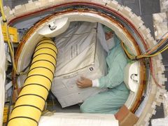 Nakládání čerpadla pro kosmickou toaletu do raketoplánu Discovery.