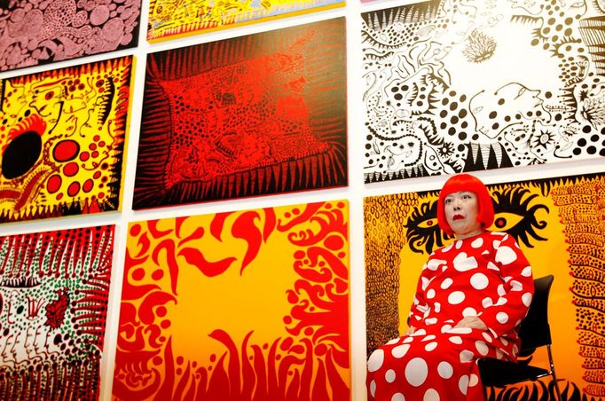 Umělkyně Yayoi Kusama pózuje pro fotografy s jejím uměleckým dílem "Láska přichází na zemi nesouc sebou příběh vesmíru" v moderní galerii Tate v Londýně, 7. února 2012. Retrospektivní výstava jejího díla začíná 8. února a potrvá až do 5. června 2012. REUTERS/Luke MacGregor