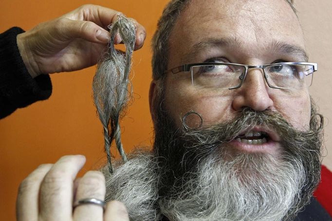 Elmar Weisser of Germany, 48, is helped by his wife as he gets ready to participate in the 2012 European Beard and Moustache Championships in Wittersdorf near Mulhouse, Eastern France, September 22, 2012. More than a hundred participants competed in the first European Beard and Moustache Championships organized in France. REUTERS/Vincent Kessler (FRANCE - Tags: SOCIETY TPX IMAGES OF THE DAY) Published: Zář. 22, 2012, 7:26 odp.