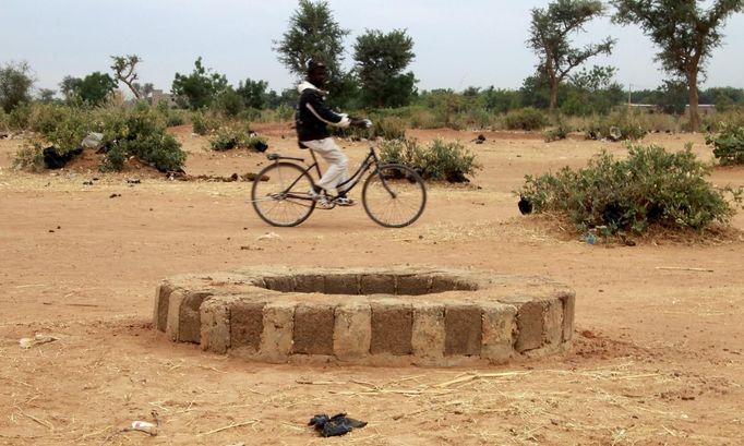 A man rides past the well where the bodies of suspected Islamist rebels, according to UN director of Human Rights Watch, Philippe Bolopion, had been dumped in Sevare January 28, 2013. Rights groups are worried ethnic reprisals will spread as parts of the north are retaken by Malian and French troops. REUTERS/Eric Gaillard (MALI - Tags: CIVIL UNREST CONFLICT) Published: Led. 28, 2013, 11:24 dop.