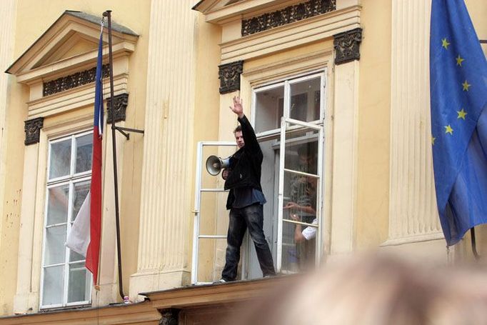 Jeden z demonstrantů se pokouší uklidnit kolegy z okna ministerstva školství.