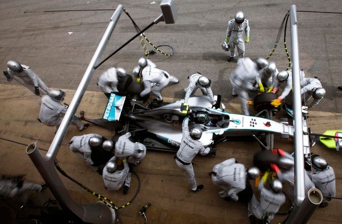 Crew members of Mercedes Formula One driver Nico Rosberg of Germany service the car at pit stop during the Spanish F1 Grand Prix at the Barcelona-Catalunya Circuit in Mon