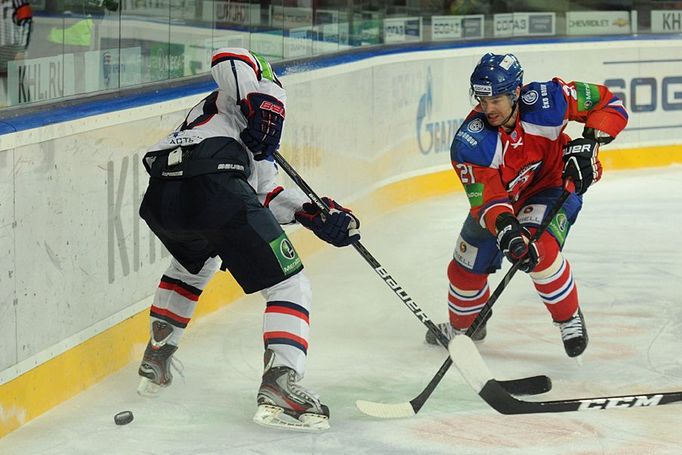 Hokejista Lva Praha Jakub Klepiš bojuje o puk se soupeřem v utkání KHL 2012/13 proti Novosibirsku.