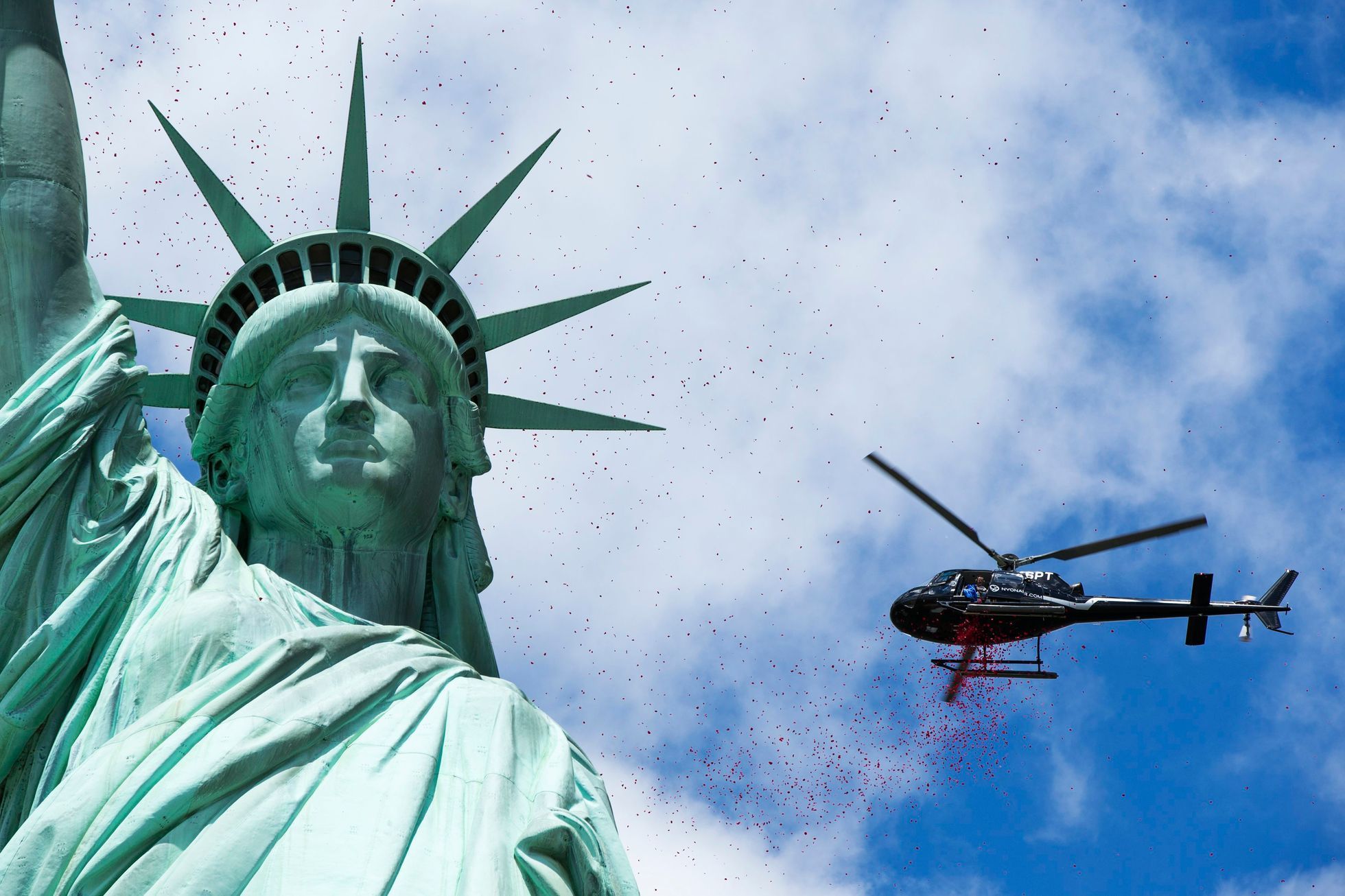 Rose petals dropped by helicopters fall around the Statue of Liberty in New York
