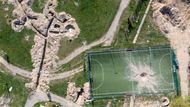 Letecký záběr na ruské zákopy a válkou poničené fotbalové hřiště v Hostomelu, 6. května 2022. V dubnu stejného roku se odtud ruská vojska stáhla.