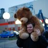 A man carrying a Teddy bear walks past installation Border of Light near to East Side Gallery in Berlin