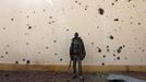 A Malian soldier stands near a wall with bullet holes in the recently liberated town of Konna January 26, 2013. REUTERS/Eric Gaillard (MALI - Tags: CIVIL UNREST CONFLICT MILITARY TPX IMAGES OF THE DAY) Published: Led. 26, 2013, 2:15 odp.