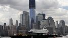 The Space Shuttle Enterprise, passes lower Manhattan and the still under construction 1 World Trade Center tower (C) as it rides on a barge in New York harbor, June 6, 2012. The Space Shuttle Enterprise was being moved up the Hudson River to be placed at the Intrepid Sea, Air and Space Museum. REUTERS/Mike Segar (UNITED STATES - Tags: TRANSPORT SCIENCE TECHNOLOGY) Published: Čer. 6, 2012, 5:15 odp.