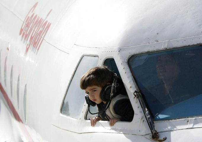 A child leans from the cockpit window of a plane at a kindergarten in the town of Rustavi some 25 km (15 miles) south of Tbilisi, October 31, 2012. The fully functional Soviet-era Yakovlev Yak-40 plane has been installed in the kindergarten courtyard and refurbished as a children's playground. REUTERS/David Mdzinarishvili (GEORGIA - Tags: EDUCATION SOCIETY TPX IMAGES OF THE DAY) Published: Říj. 31, 2012, 11:18 dop.