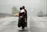 Yannis Behrakis / září 2015: Syrský uprchlík líbá na silnici poblíž řeckého Idomeni svou dceru a kráčí směrem k hranici s Makedonií.