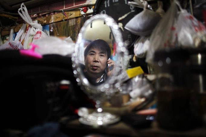 Xiao Cao, a 57-year-old gay man, talks on the phone inside his eight square metre apartment in Shanghai April 6, 2012. China's gay community has long been on the edges of society but it is gradually becoming more accepted. Cao, who is an unemployed drag queen, is one whose life lifts the curtain on a less romanticised view of Chinese homosexuals. Living in an eight-square-metre apartment behind a public toilet and with a monthly income of 500 yuan ($79) from social insurance, he passes his days dancing in public and spending time with friends at gay clubs. Picture taken April 6, 2012. REUTERS/Aly Song (CHINA - Tags: SOCIETY) CHINA OUT. NO COMMERCIAL OR EDITORIAL SALES IN CHINA. ATTENTION EDITORS PICTURE 06 OF 28 OF PACKAGE 'GAY AND OUT IN CHINA' TO FIND ALL IMAGES SEARCH 'GAY OUT CHINA' Published: Čer. 1, 2012, 12:35 dop.