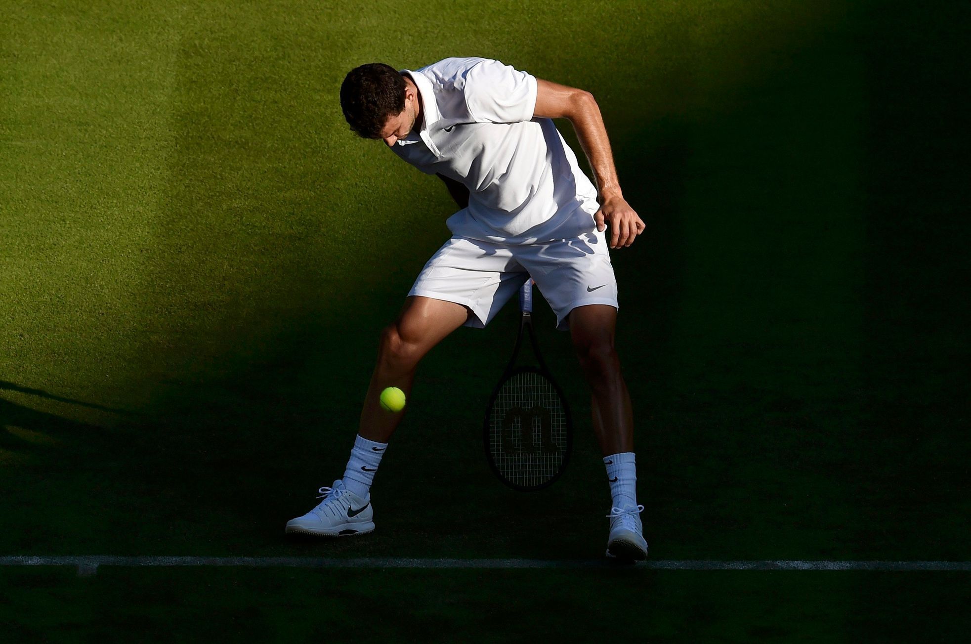 Grigor Dimitrov of Bulgaria plays a shot through his legs during his match against Federico Delbonis of Argentina at the Wimbledon Tennis Championships in London