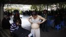 Xiao Cao, a 57-year-old gay man, puts on a bra before his performance at Manxi park in Shanghai April 8, 2012. China's gay community has long been on the edges of society but it is gradually becoming more accepted. Cao, who is an unemployed drag queen, is one whose life lifts the curtain on a less romanticised view of Chinese homosexuals. Living in an eight-square-metre apartment behind a public toilet and with a monthly income of 500 yuan ($79) from social insurance, he passes his days dancing in public and spending time with friends at gay clubs. Picture taken April 8, 2012. REUTERS/Aly Song (CHINA - Tags: SOCIETY) CHINA OUT. NO COMMERCIAL OR EDITORIAL SALES IN CHINA. ATTENTION EDITORS PICTURE 18 OF 28 OF PACKAGE 'GAY AND OUT IN CHINA' TO FIND ALL IMAGES SEARCH 'GAY OUT CHINA' Published: Čer. 1, 2012, 12:40 dop.