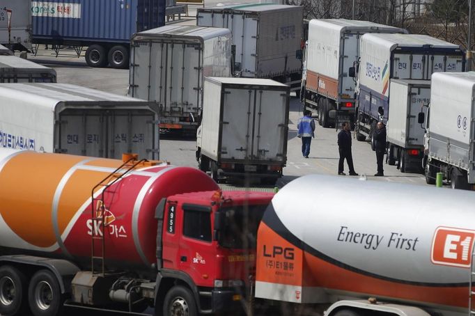 Truck drivers talk between South Korean trucks turning back to South Korea's CIQ (Customs, Immigration and Quarantine) after they were banned from entering the Kaesong industrial complex in North Korea, just south of the demilitarised zone separating the two Koreas, in Paju, north of Seoul, April 3, 2013. North Korean authorities were not allowing any South Korean workers into a joint industrial park on Wednesday, South Korea's Unification Ministry and a Reuters witness said, adding to tensions between the two countries. REUTERS/Kim Hong-Ji (SOUTH KOREA - Tags: MILITARY POLITICS BUSINESS TRANSPORT) Published: Dub. 3, 2013, 4:38 dop.