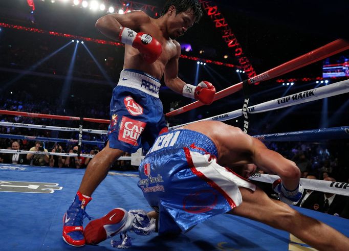 Chris Algieri of the U.S. falls as he takes a punch from Manny Pacquiao (L) of the Philippines during their World Boxing Organisation (WBO) 12-round welterweight title fi