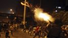 A riot police officer fires tear gas during clashes between anti-Mursi protesters, and members of the Muslim Brotherhood and ousted Egyptian President Mohamed Mursi supporters, in Cairo