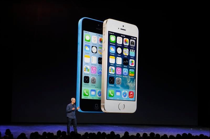 Apple CEO Tim Cook speaks in front of an image of the iPhone 5 and the iPhone 5s during an Apple event at the Flint Center in Cupertino