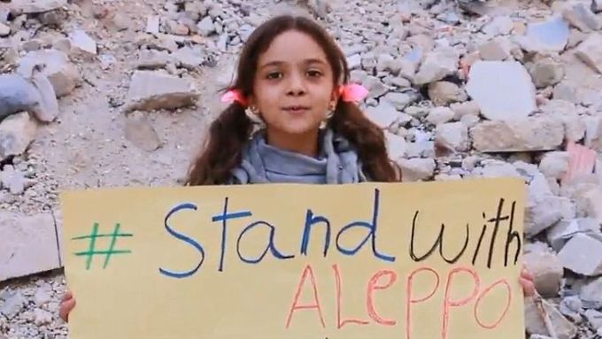 Sedmiletá Bana Al Abed s transparentem v rozbombardované ulici Aleppa