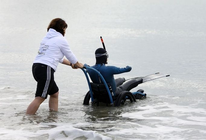 File photo dated 16/09/10 of French limbless swimmer Philippe Croizon is helped into the sea by team member Valerie Carbonnel during a training session in Folkestone, Kent. Philippe Croizon today became the first limbless person to swim the Channel.