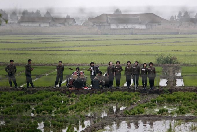 RNPS IMAGES OF THE YEAR 2012 - A music group performs on a path amid fields to greet the farmers at Hwanggumpyong Island, near the North Korean town of Sinuiju and the Chinese border city of Dandong June 6, 2012. REUTERS/Jacky Chen (NORTH KOREA - Tags: SOCIETY) Published: Pro. 4, 2012, 1:20 dop.