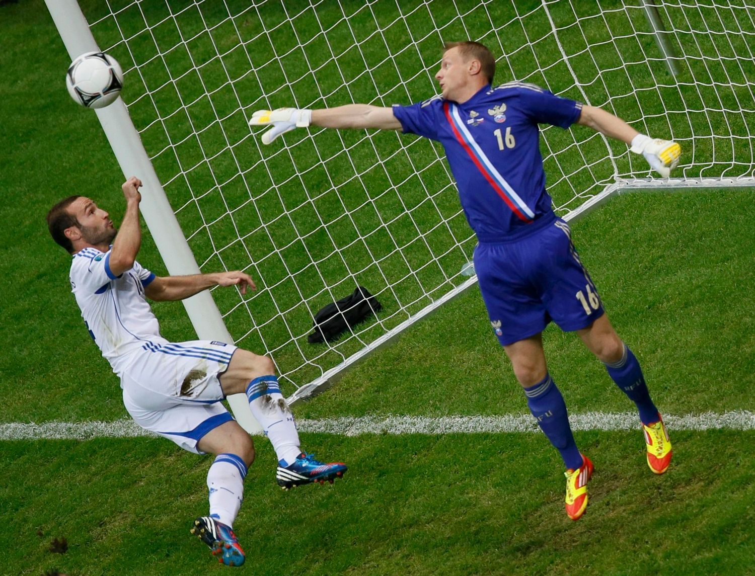 Ruský brankář Vjačeslav Malafejev vyráží střelu Řeka Dimitrise Salpingidise v utkání skupiny A na Euru 2012