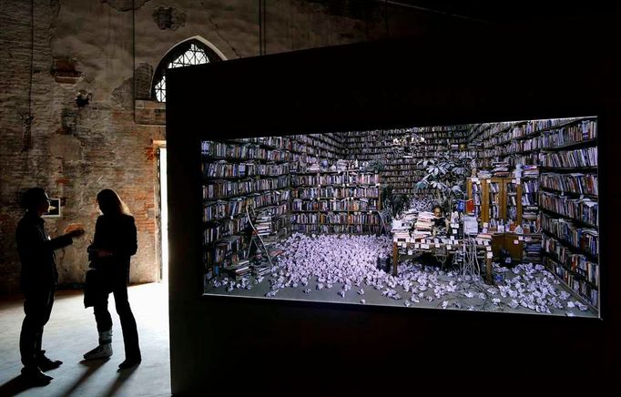 Chinese artist He Yunchang (L) talks to a visitor near his installation called "Transfiguration" at the China pavilion