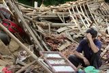 Muž sedí ve vesnici Taolin před svým domem, který se zřítil při sesuvech půdy. Podle čínské tiskové agentury Xinhua zemřelo v provincii Fu-ťien pod lavinou bahna 25 lidí a dalších více než 15 se stále pohřešuje.
