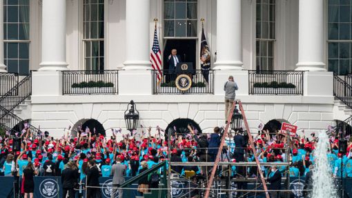 Donald Trump zdraví z balkonu Bílého domu dav svých příznivců.