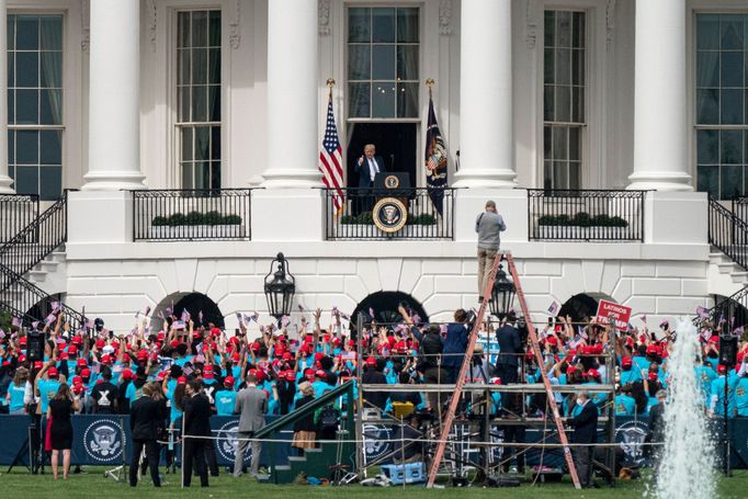 Donald Trump zdraví z balkonu Bílého domu dav svých příznivců.