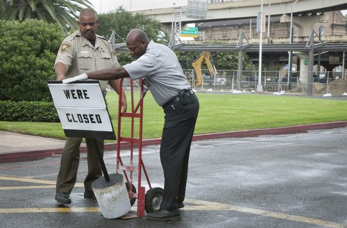 An Orleans Parish Sheriffs deputy and worker set up a sign outside the bus and train terminal after it was closed due to Tropical Storm Isaac in New Orleans, Louisiana August 28, 2012. REUTERS/Lee Celano (UNITED STATES - Tags: ENVIRONMENT DISASTER) Published: Srp. 28, 2012, 3:28 odp.