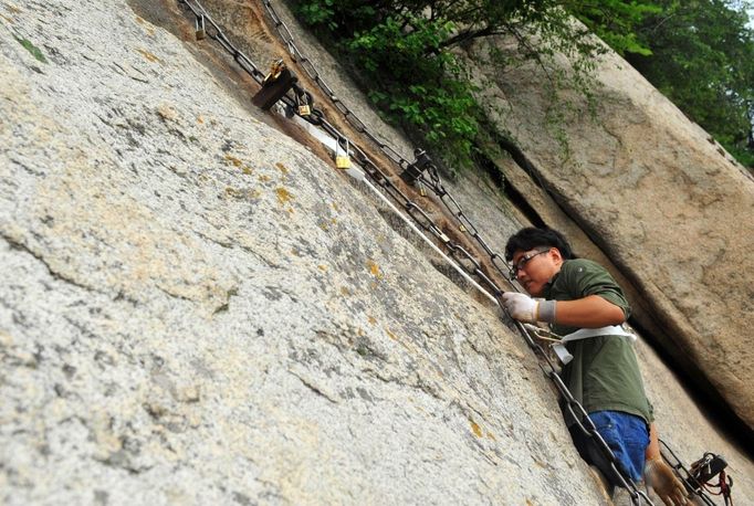 HUAYIN, CHINA - AUGUST 13: (CHINA OUT) Legless man Chen Zhou climbs the Huashan Mountain on August 13, 2012 in Huayin, Shaanxi Province of China. Legless 29-year-old man Chen Zhou from Cangshan of Shandong Province spent two days, 19 hours in total, climbing by arms to the top of Huashan Mountain. Chen lost his legs after falling off a train at the age of 13, but he has since strived to be stronger and joined in many public performances to encourage other people. Chen Zhou will climb the Taishan Mountain in Shandong province in the following months. ( automatický překlad do češtiny )