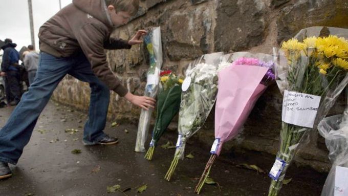 Na místo, kde byli v sobotu večer zastřeleni dva vojáci, nosí lidé květiny.