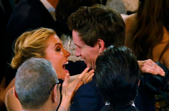 Eddie Redmayne  embraces Sienna Miller after the show at the 87th Academy Awards in Hollywood, California